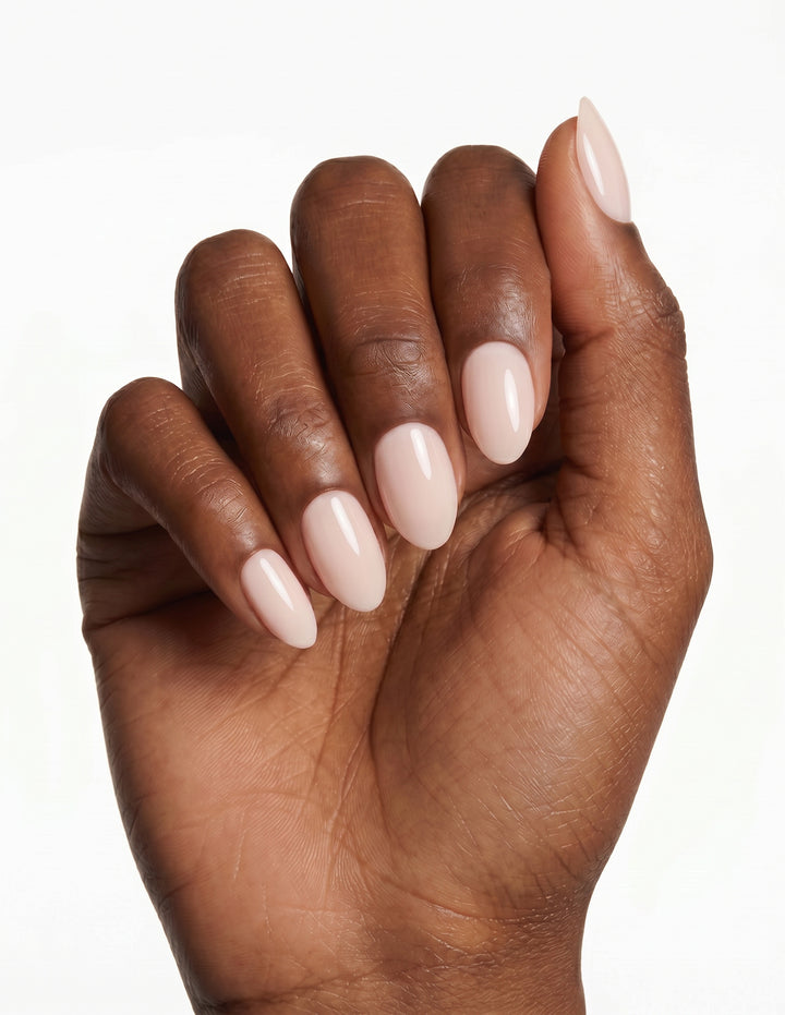 Cream Crème press-on nails — Almond (extra-short), deep-skin hand, fingers curled