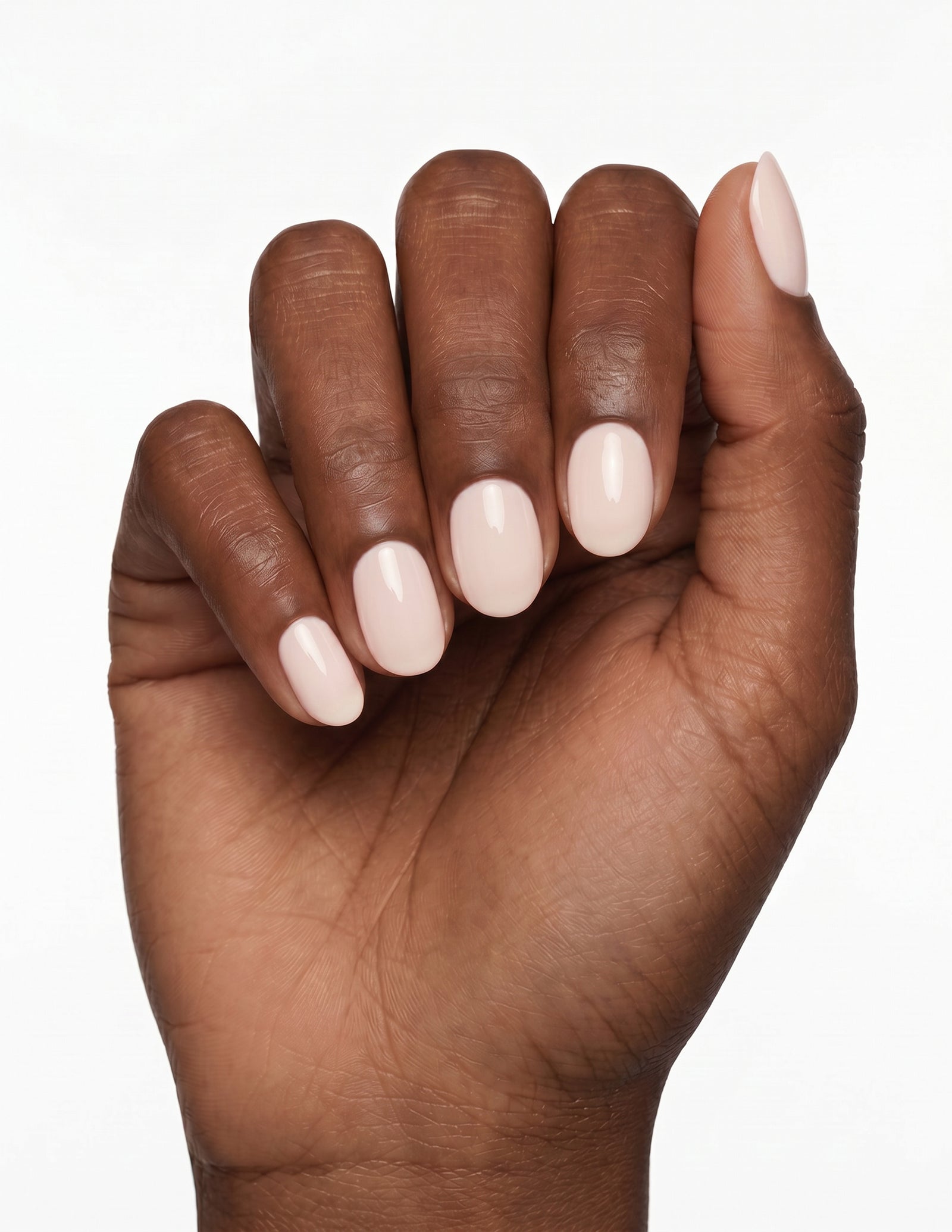 Cream Crème press-on nails — Oval (extra-short), deep-skin hand, fingers curled