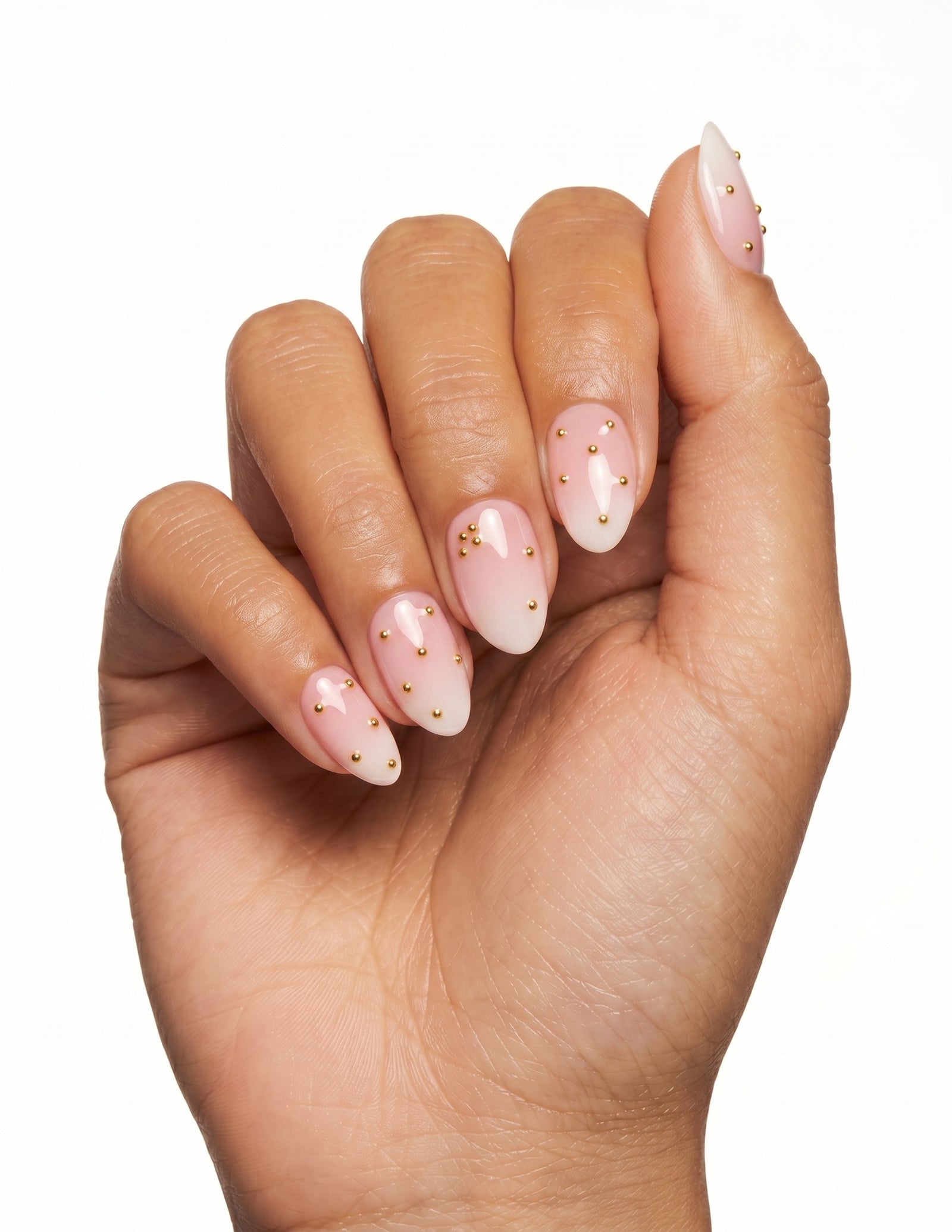Champagne Dots press-on nails — Almond (extra-short), tan hand, fingers curled
