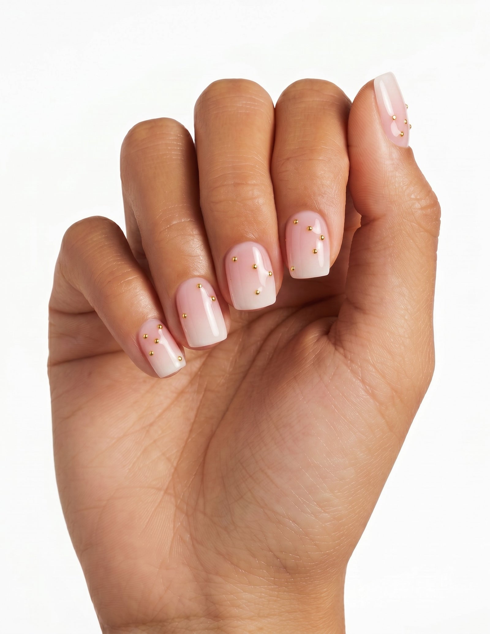 Champagne Dots press-on nails — Coffin (short), tan hand, fingers curled