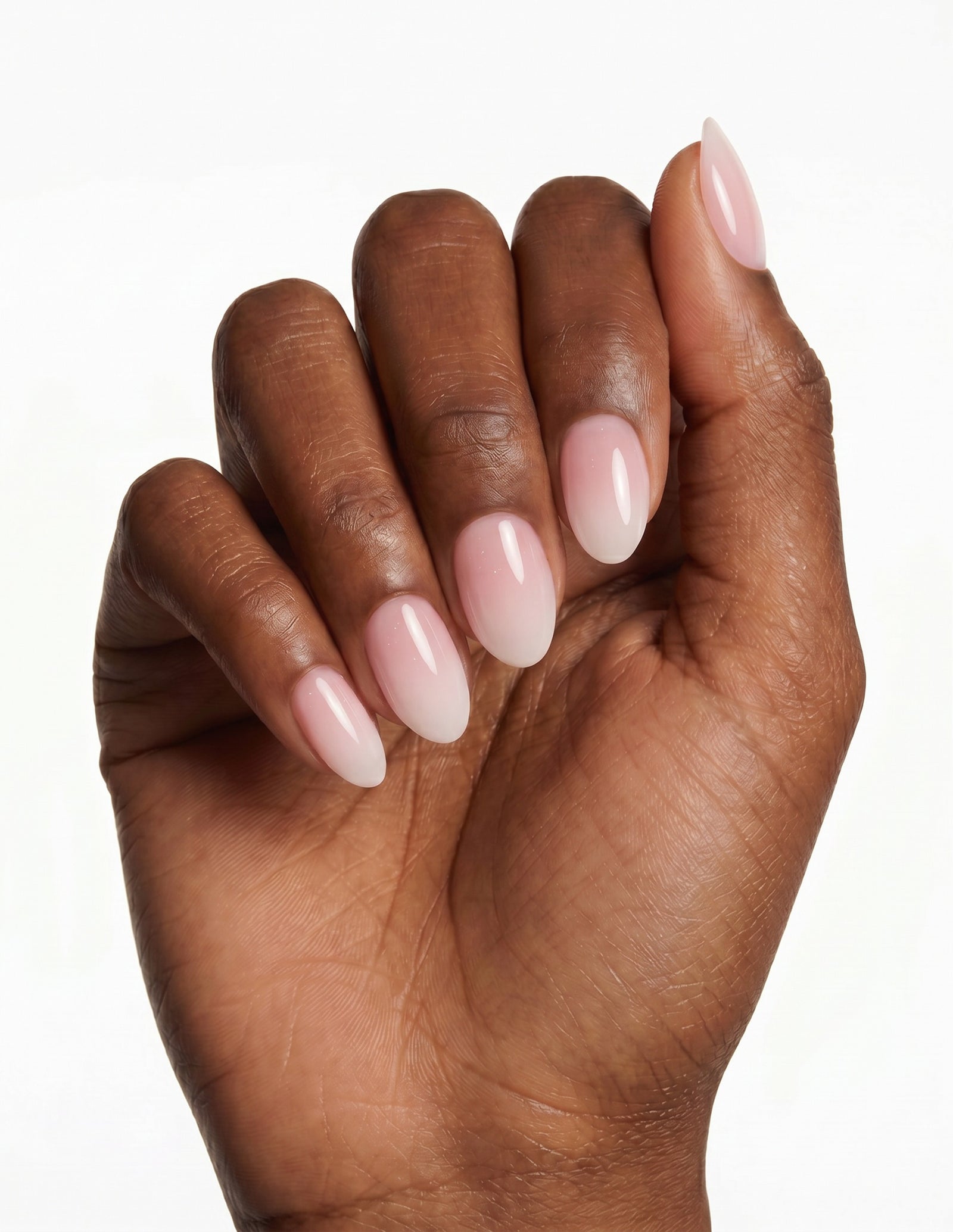 Milk Bath press-on nails — Almond (extra-short), deep-skin hand, fingers curled