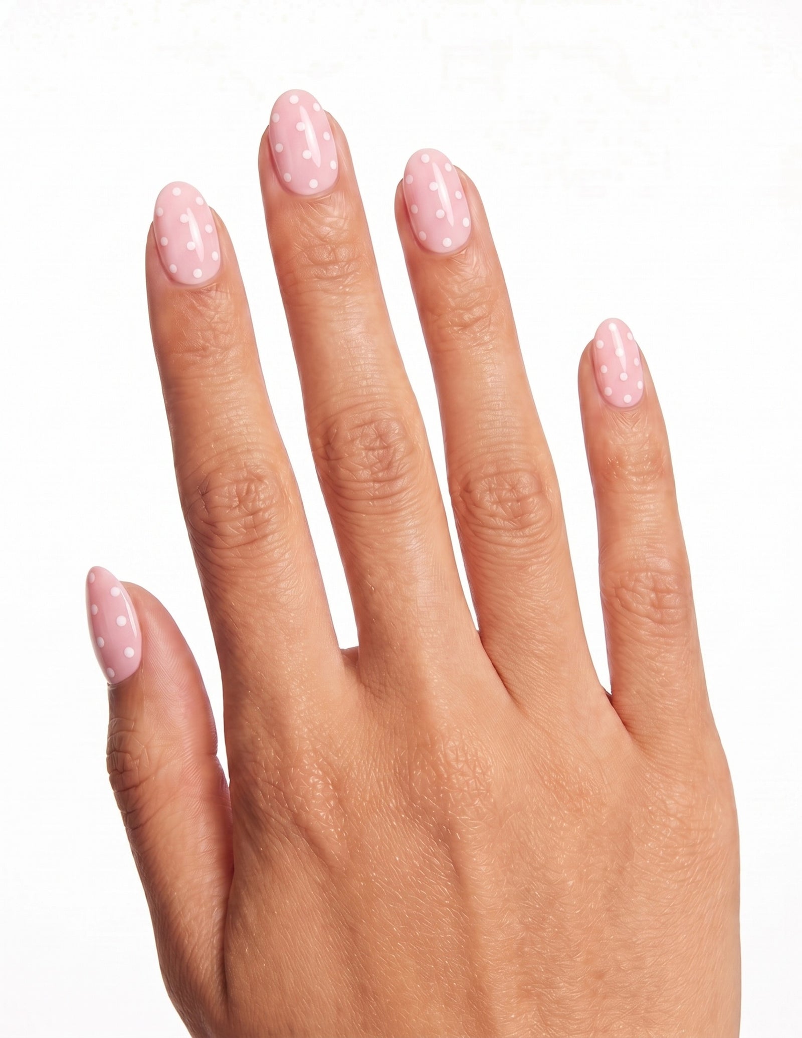 Polka Pink press-on nails — Almond (extra-short), tan hand, back of hand