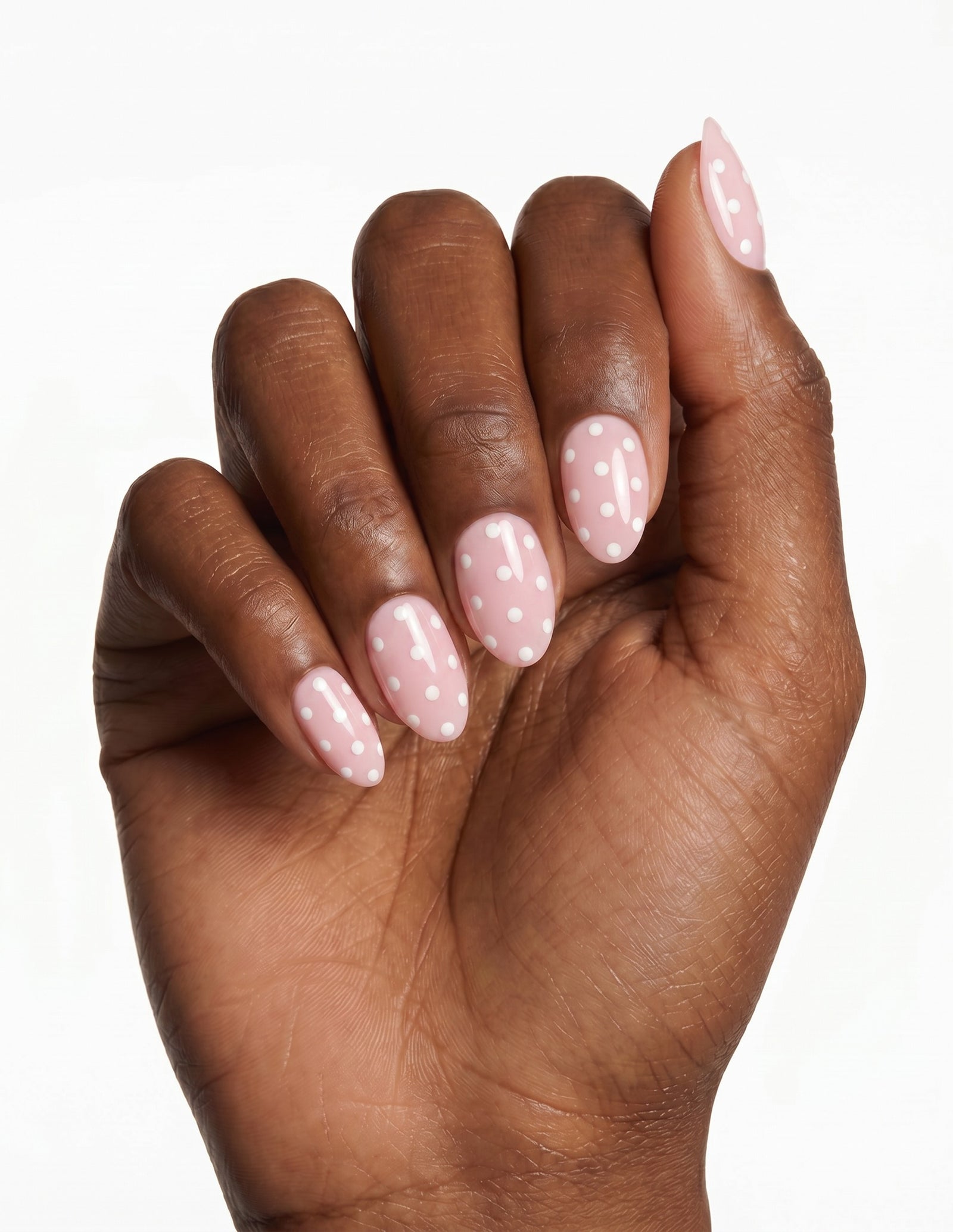 Polka Pink press-on nails — Almond (extra-short), deep-skin hand, fingers curled