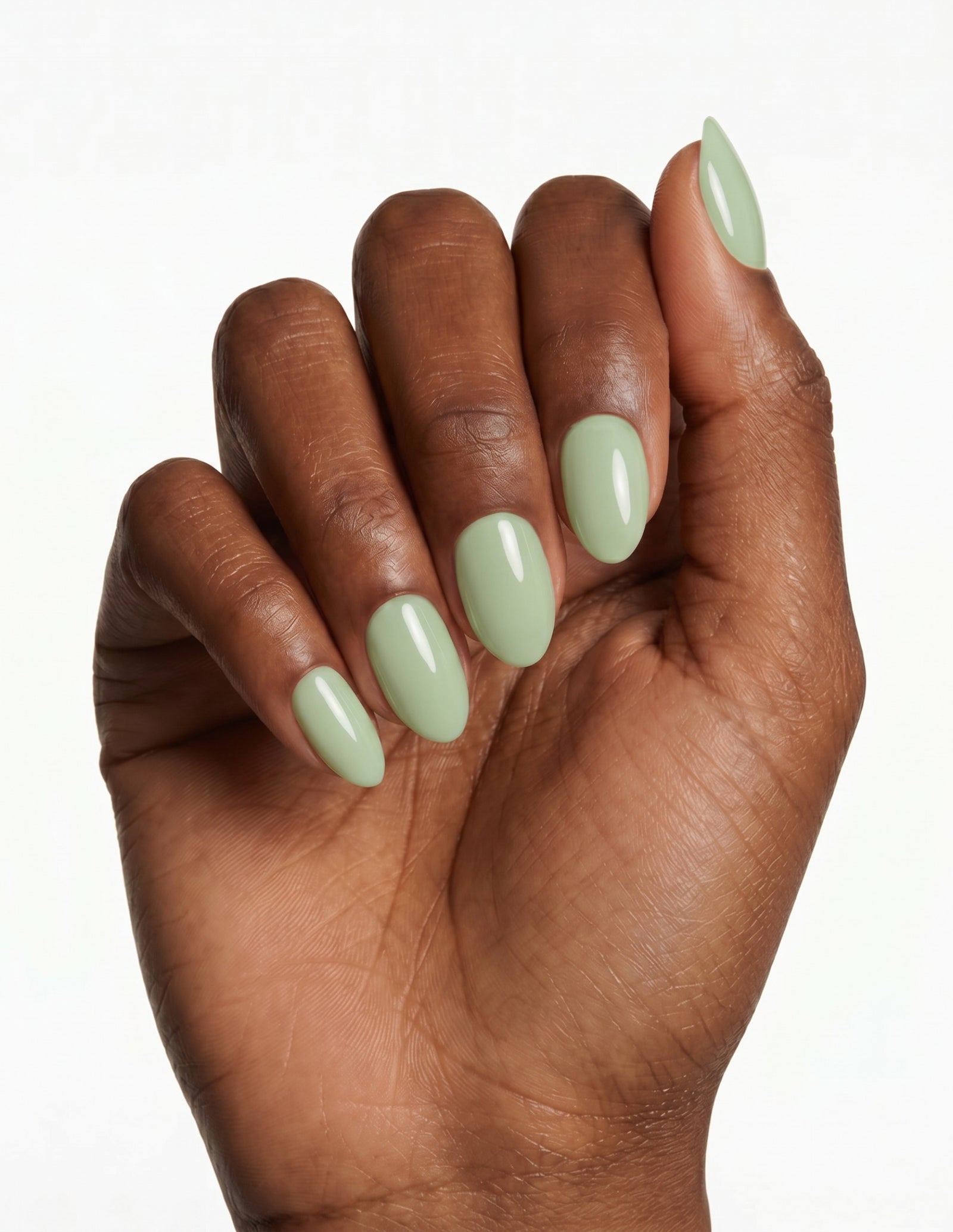 Pistachio press-on nails — Almond (extra-short), deep-skin hand, fingers curled