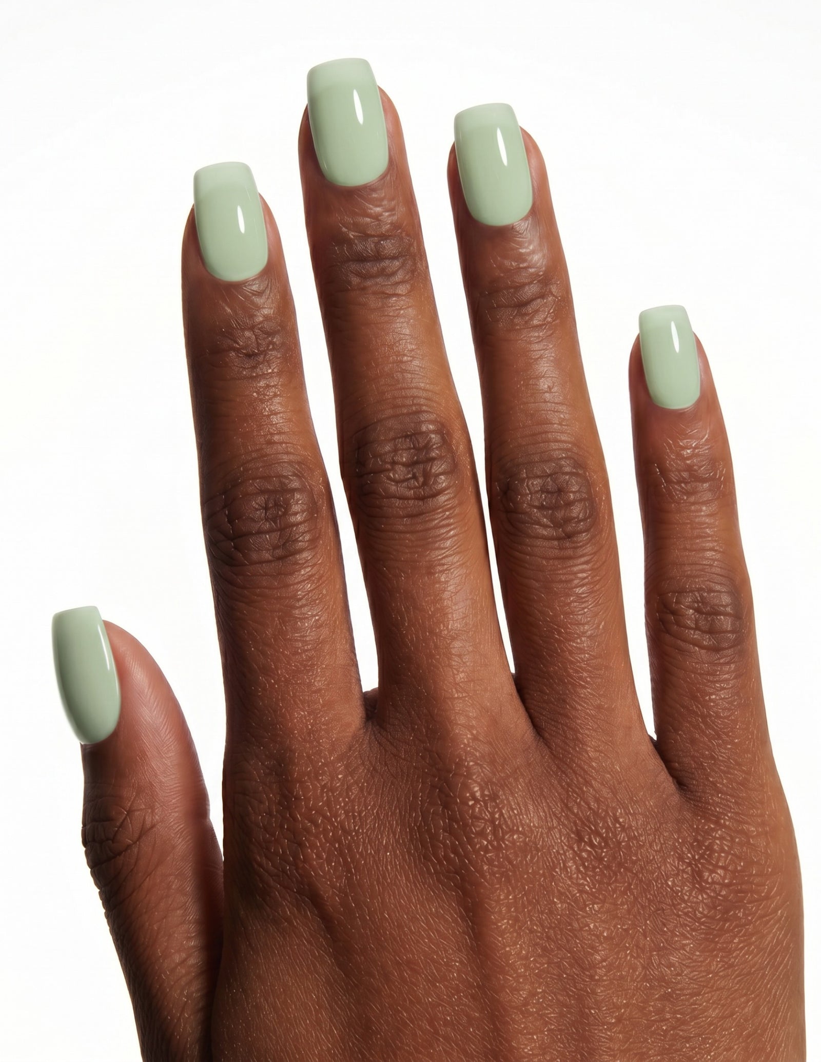 Pistachio press-on nails — Coffin (short), deep-skin hand, back of hand