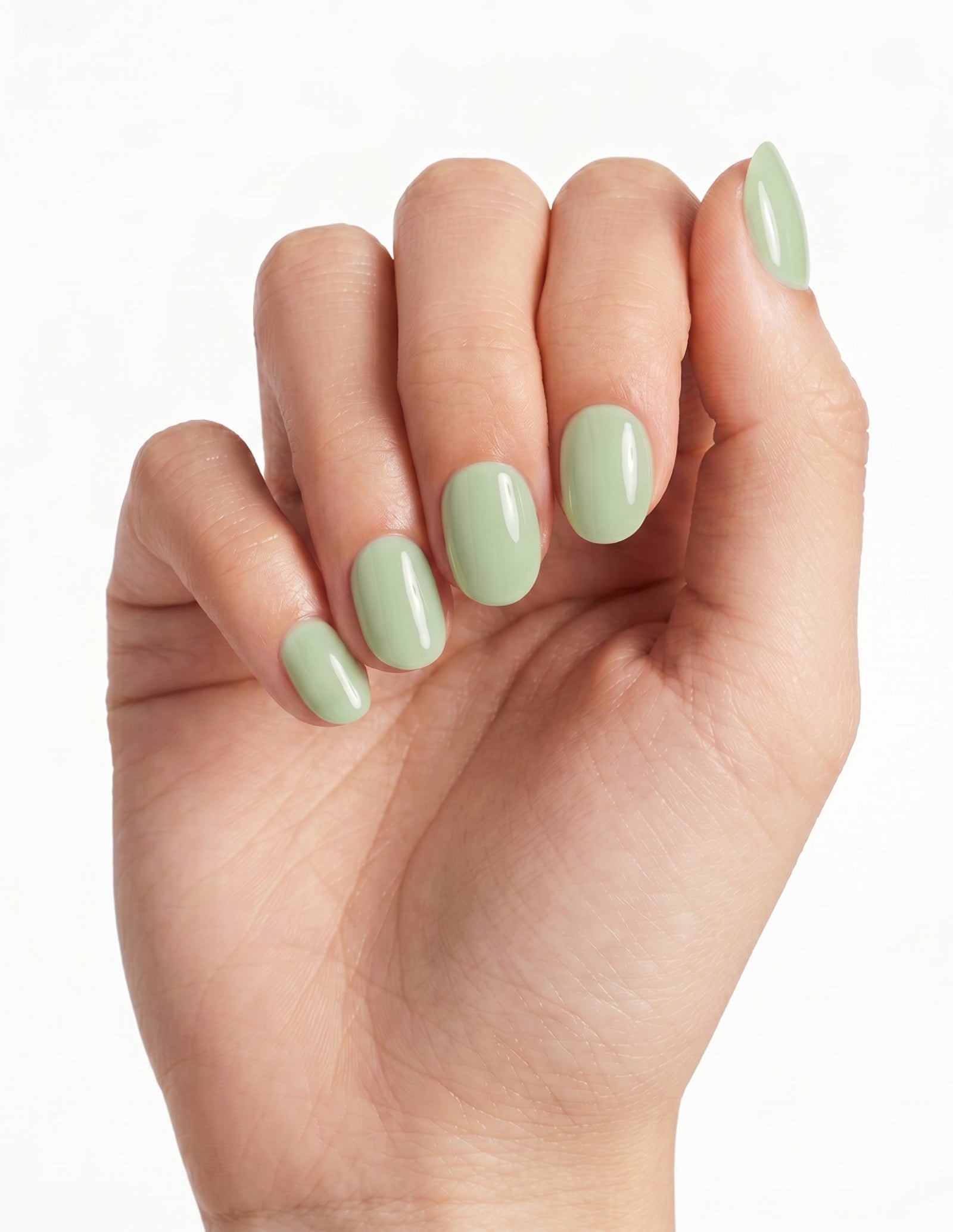 Pistachio press-on nails — Oval (extra-short), light-skin hand, fingers curled