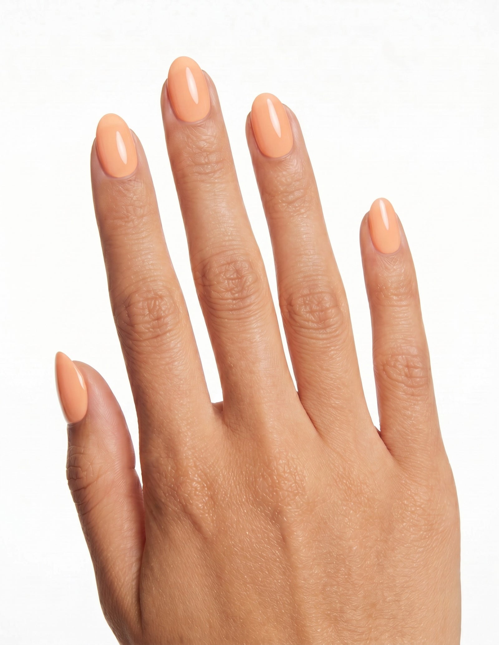 Apricot press-on nails — Almond (extra-short), tan hand, back of hand