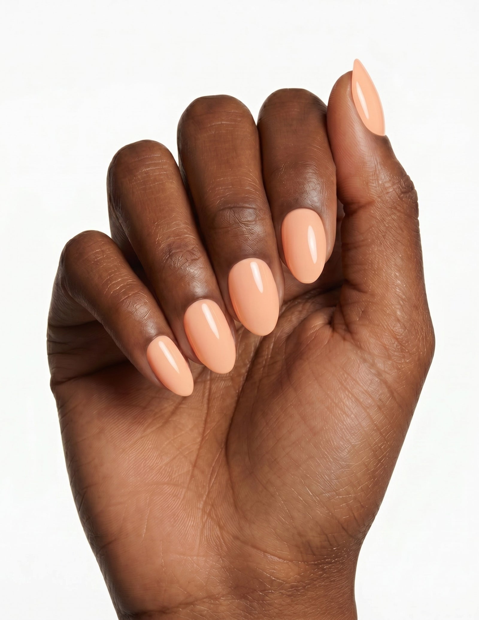 Apricot press-on nails — Almond (extra-short), deep-skin hand, fingers curled