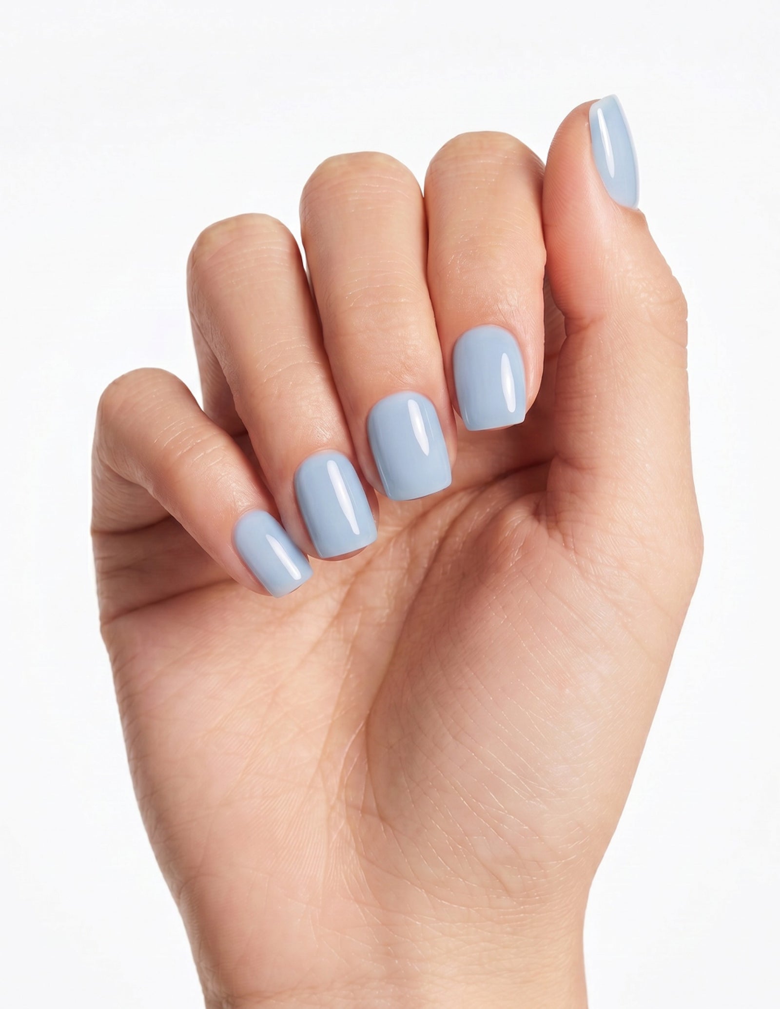 Baby Blue press-on nails — Coffin (short), light-skin hand, fingers curled