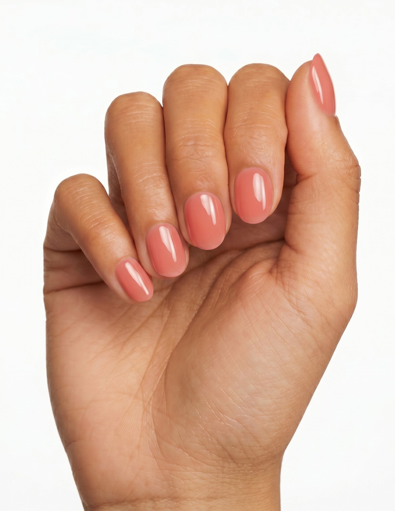 Guava press-on nails — Oval (extra-short), tan hand, fingers curled