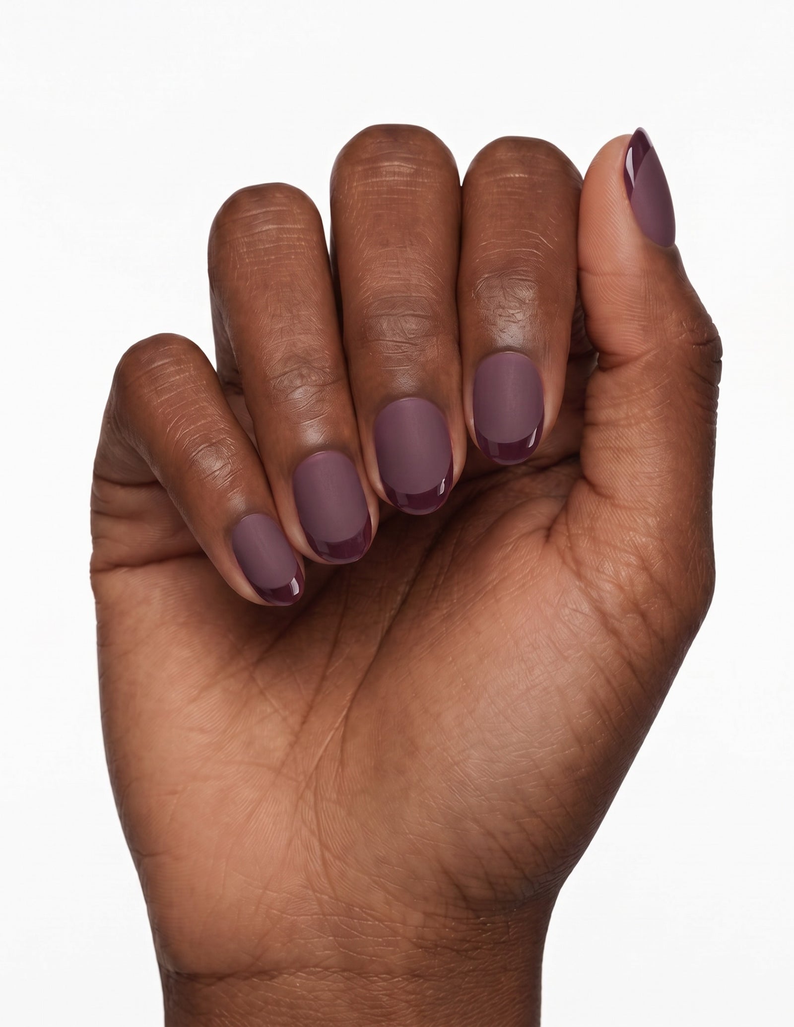 Aubergine press-on nails — Oval (extra-short), deep-skin hand, fingers curled