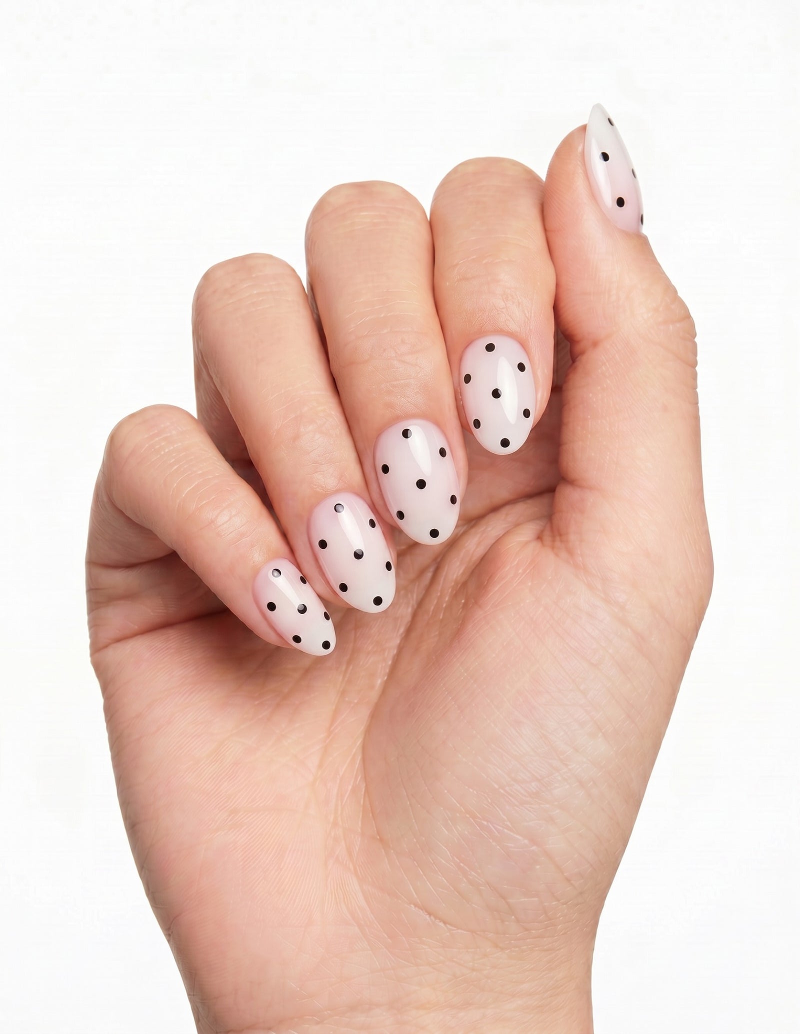 Domino press-on nails — Almond (extra-short), tan hand, fingers curled