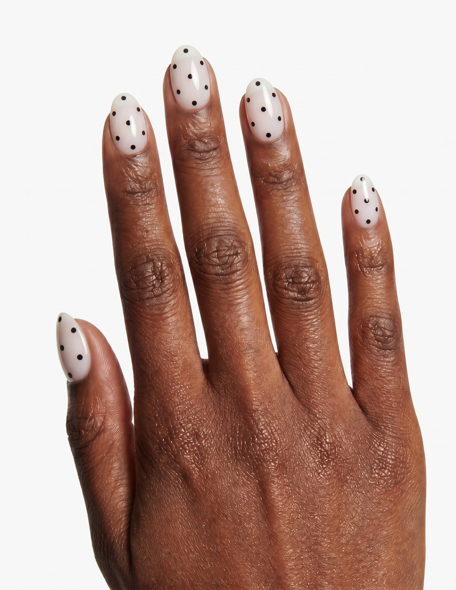 Domino press-on nails — Almond (extra-short), deep-skin hand, back of hand