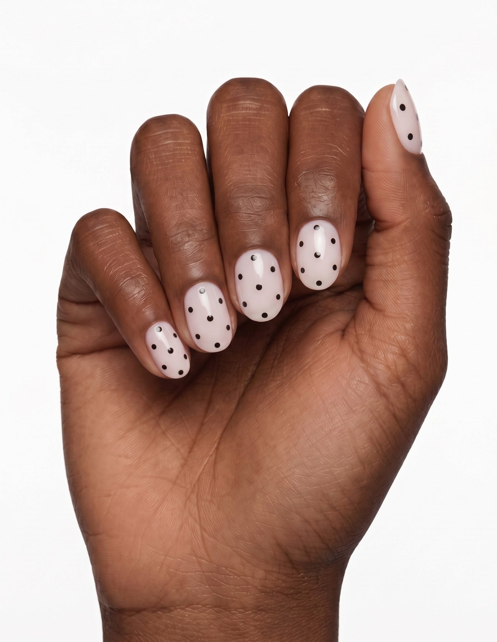 Domino press-on nails — Oval (extra-short), deep-skin hand, fingers curled