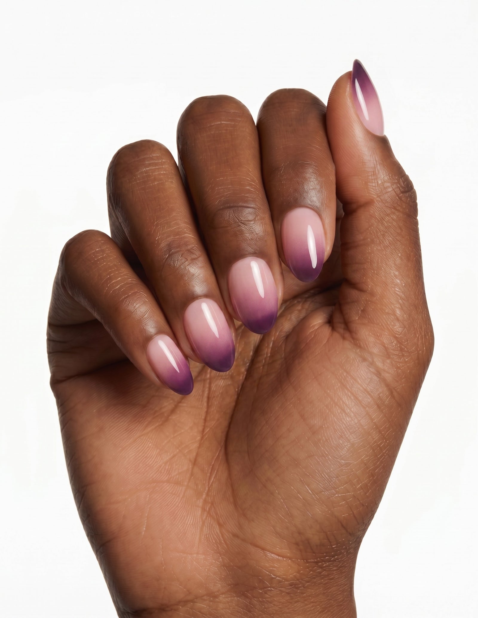 Plum Fade press-on nails — Almond (extra-short), deep-skin hand, fingers curled