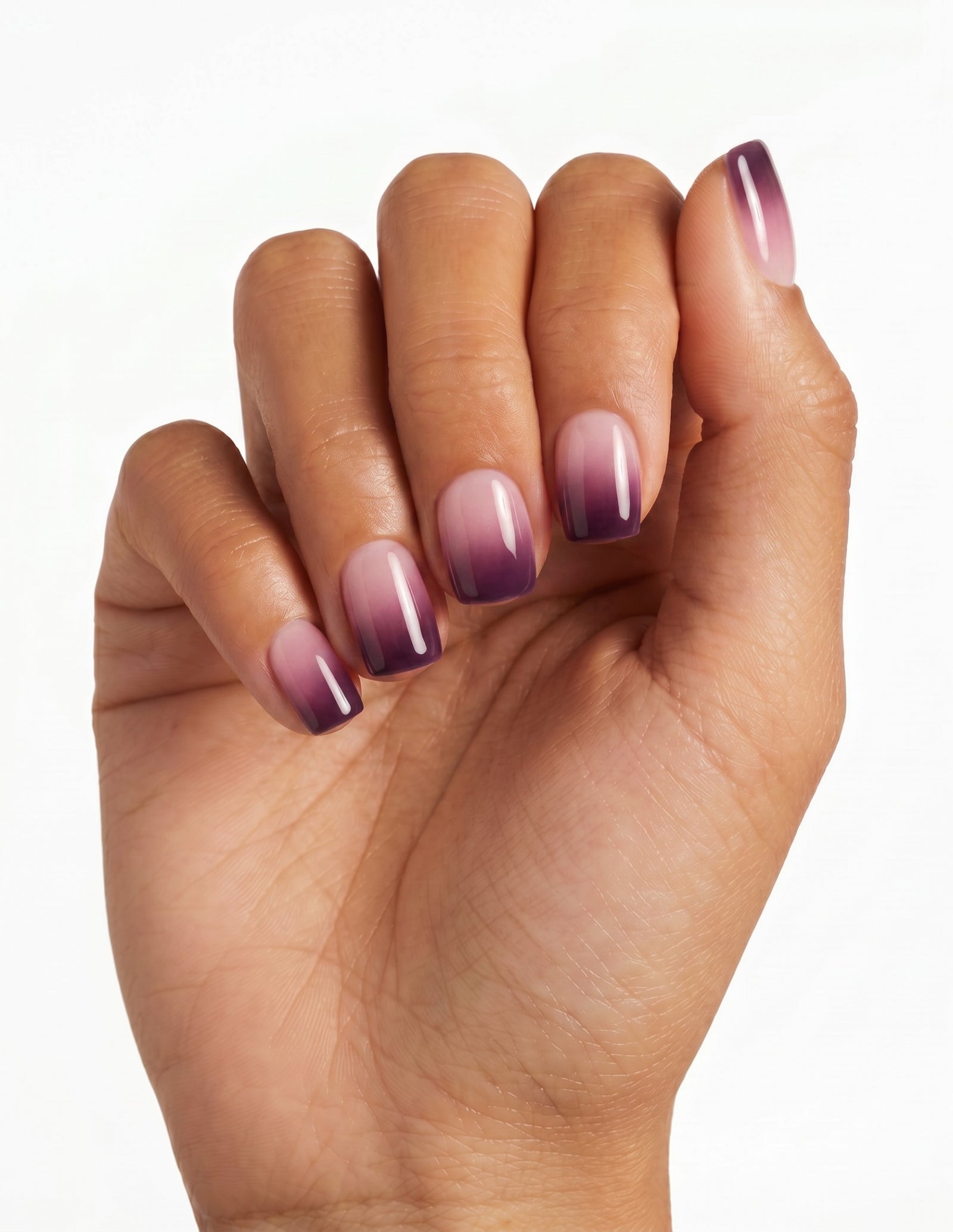 Plum Fade press-on nails — Coffin (short), tan hand, fingers curled