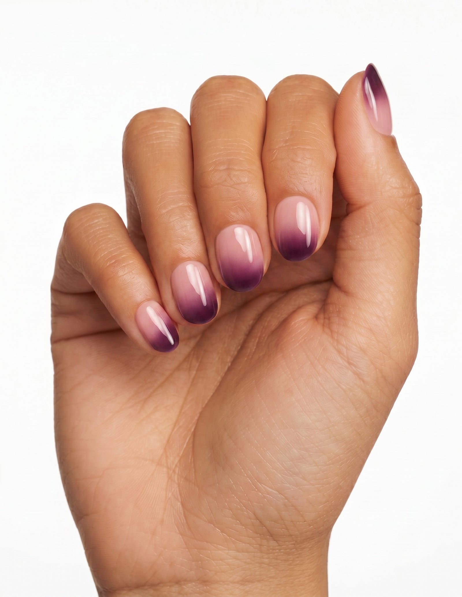 Plum Fade press-on nails — Oval (extra-short), deep-skin hand, fingers curled