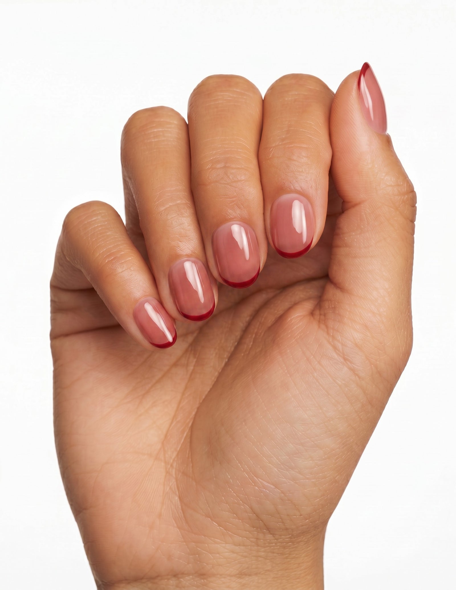 Cherry French press-on nails — Oval (extra-short), tan hand, fingers curled