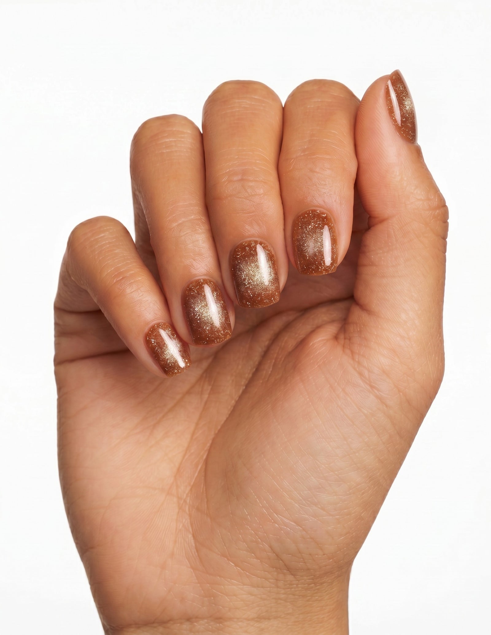 Cinnamon Velvet press-on nails — Oval (extra-short), tan hand, fingers curled