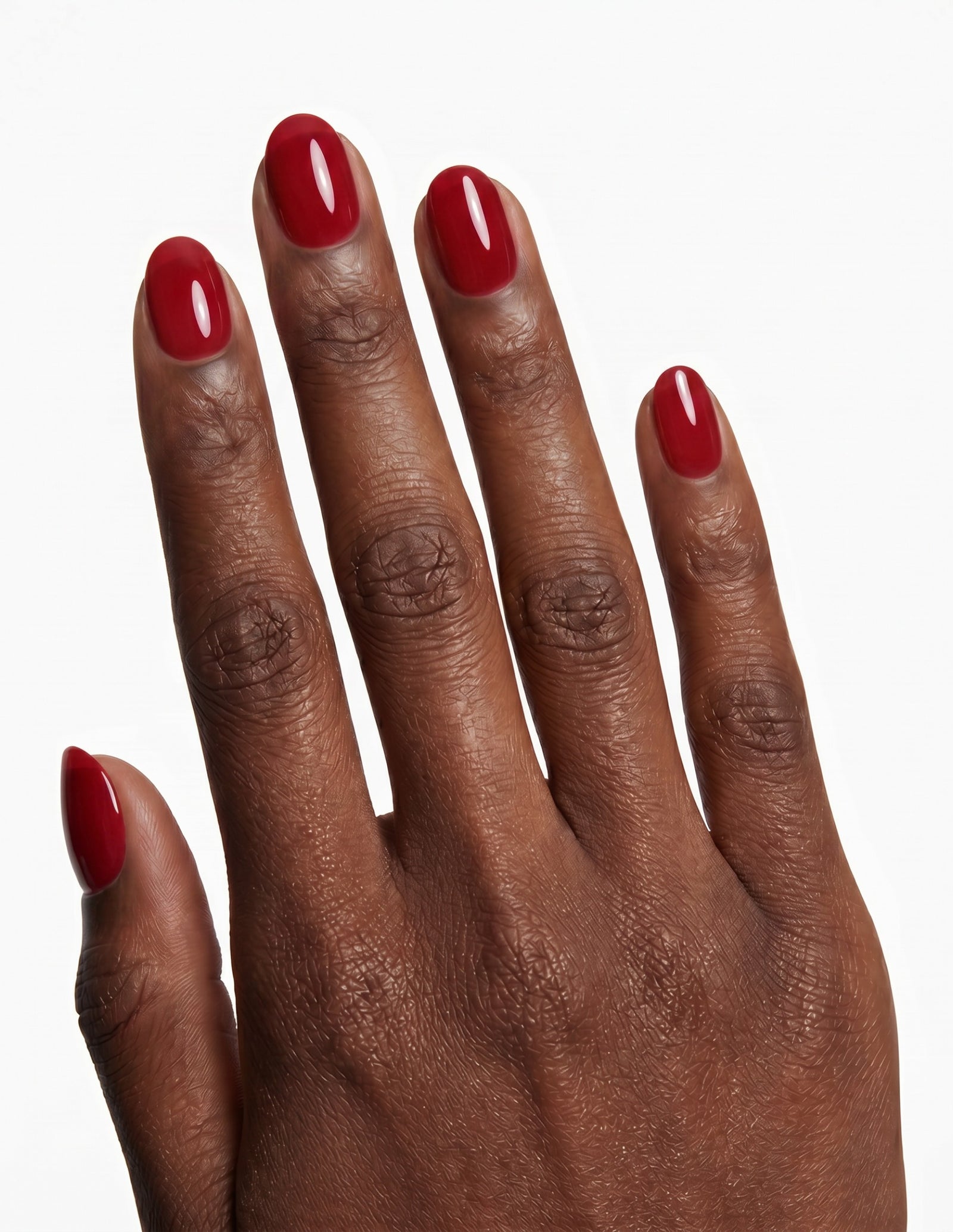 The Red press-on nails — Oval (extra-short), deep-skin hand, back of hand