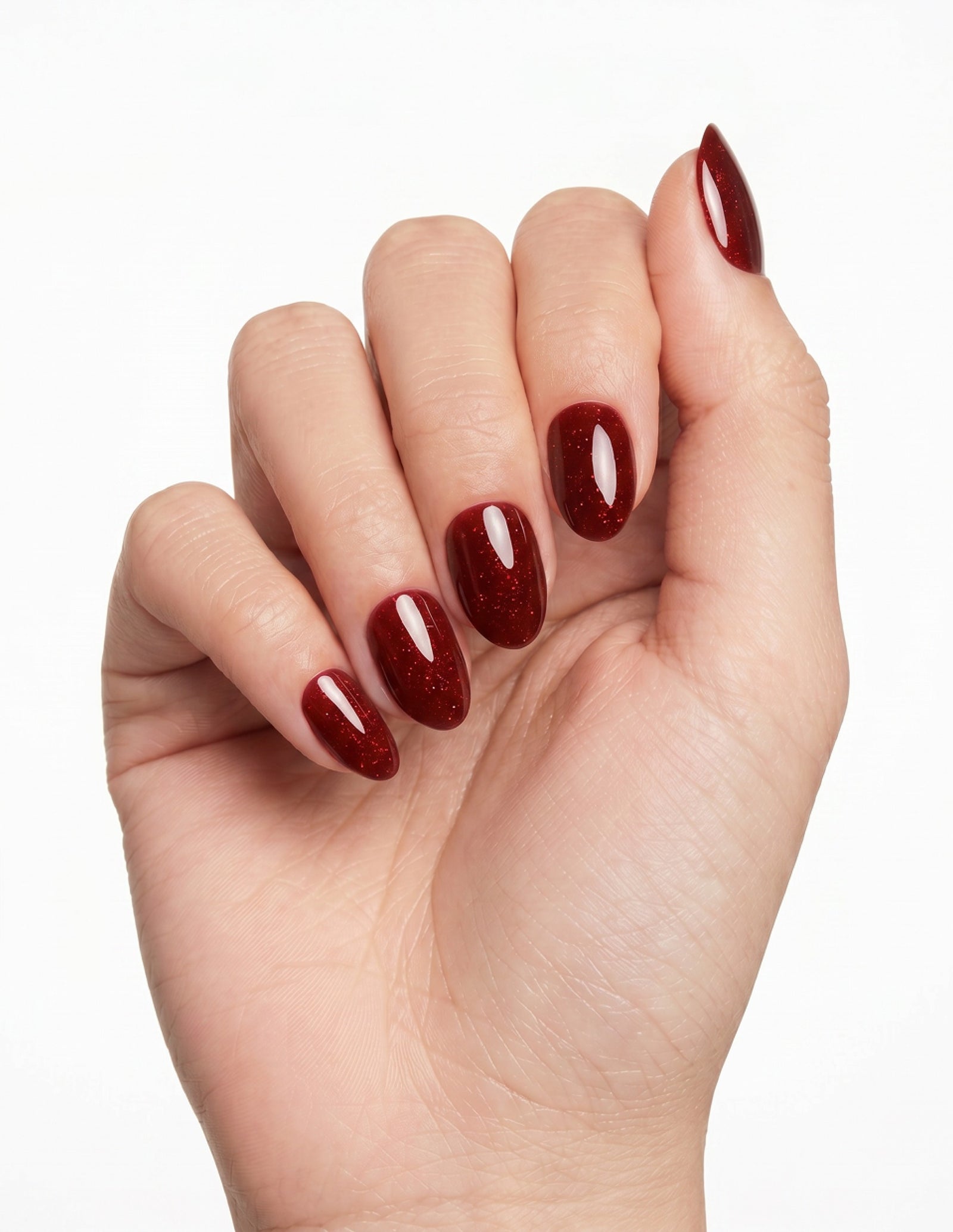 Garnet press-on nails — Almond (extra-short), light-skin hand, fingers curled