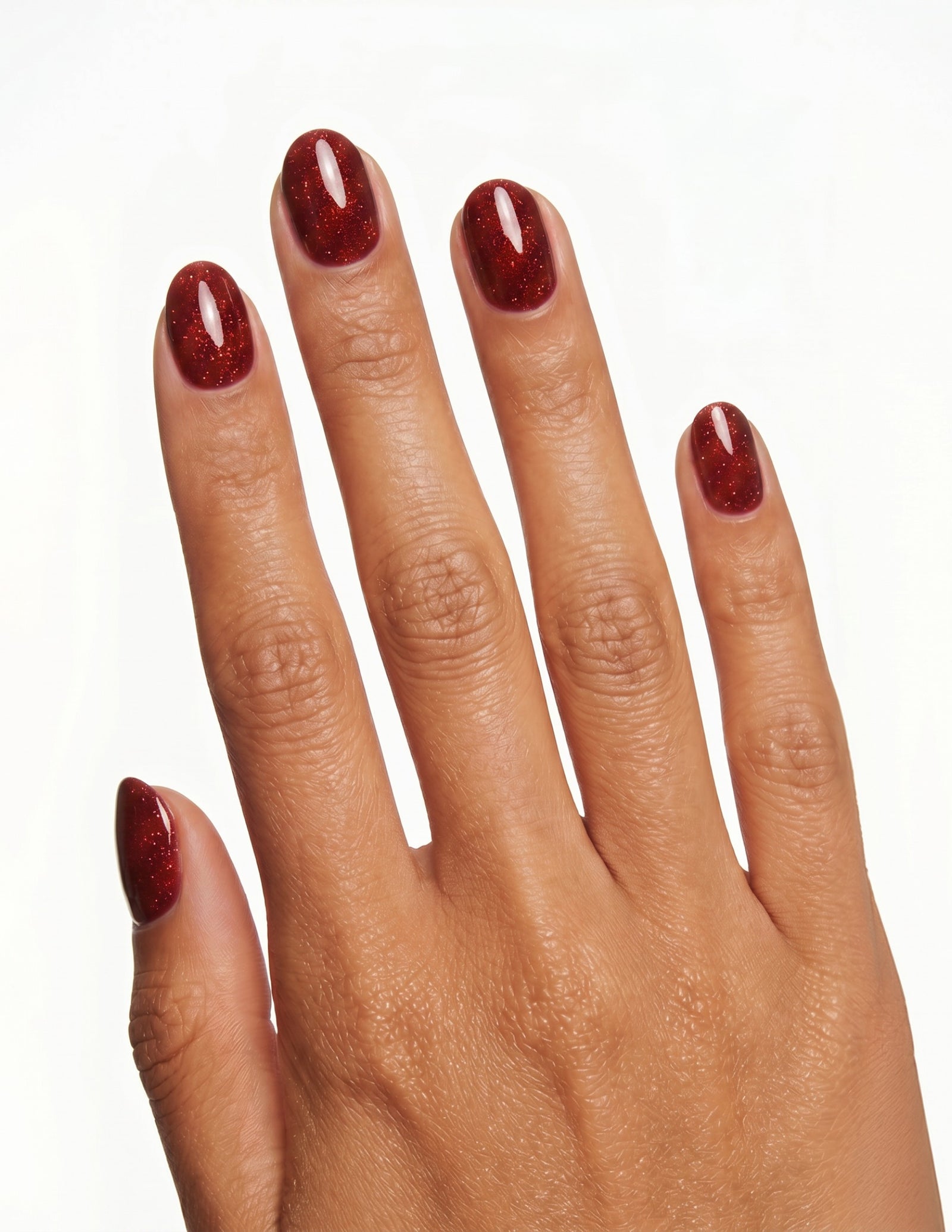 Garnet press-on nails — Oval (extra-short), tan hand, back of hand