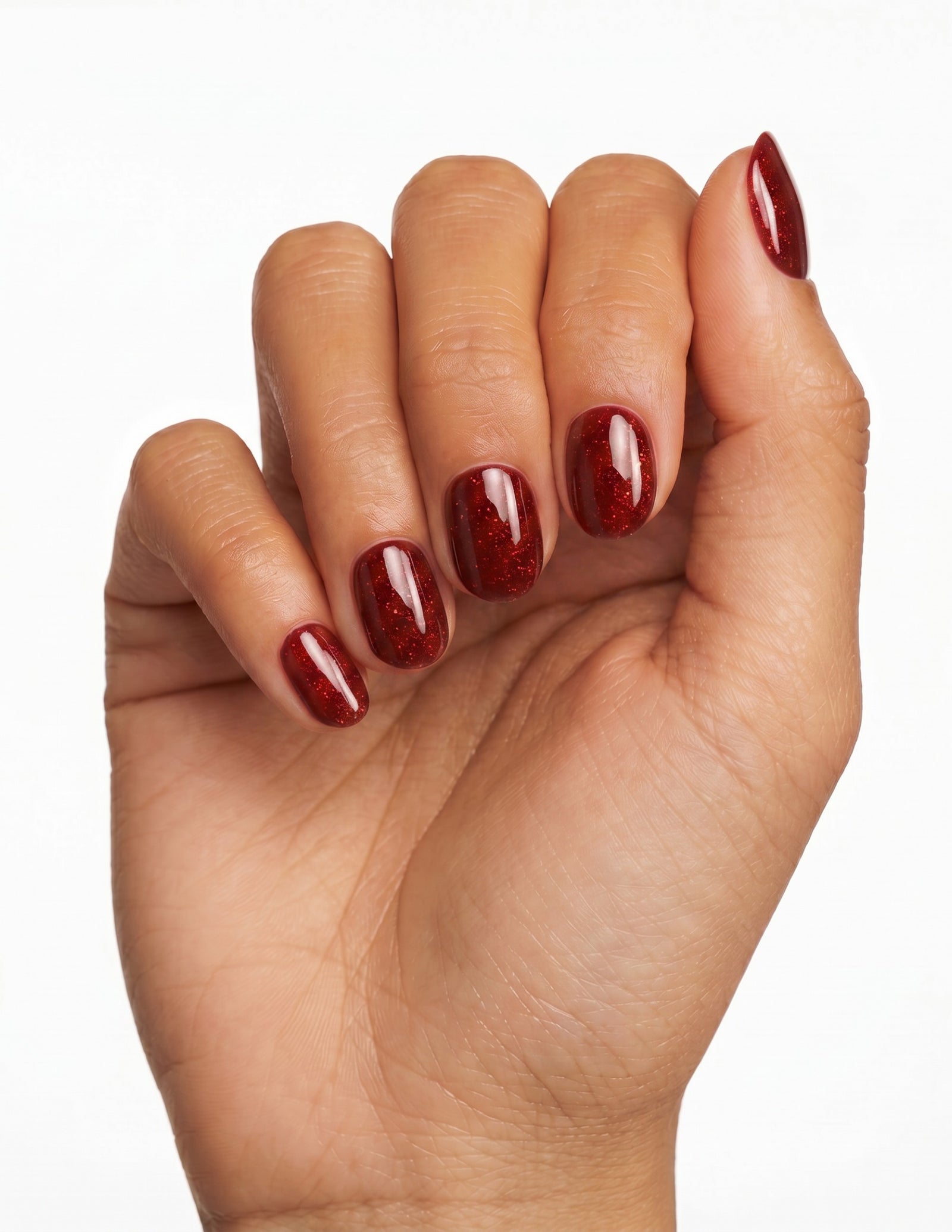 Garnet press-on nails — Oval (extra-short), deep-skin hand, fingers curled