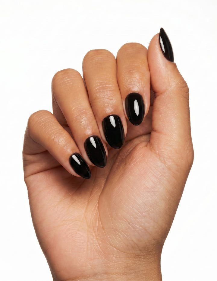 Blackout press-on nails — Almond (extra-short), tan hand, fingers curled
