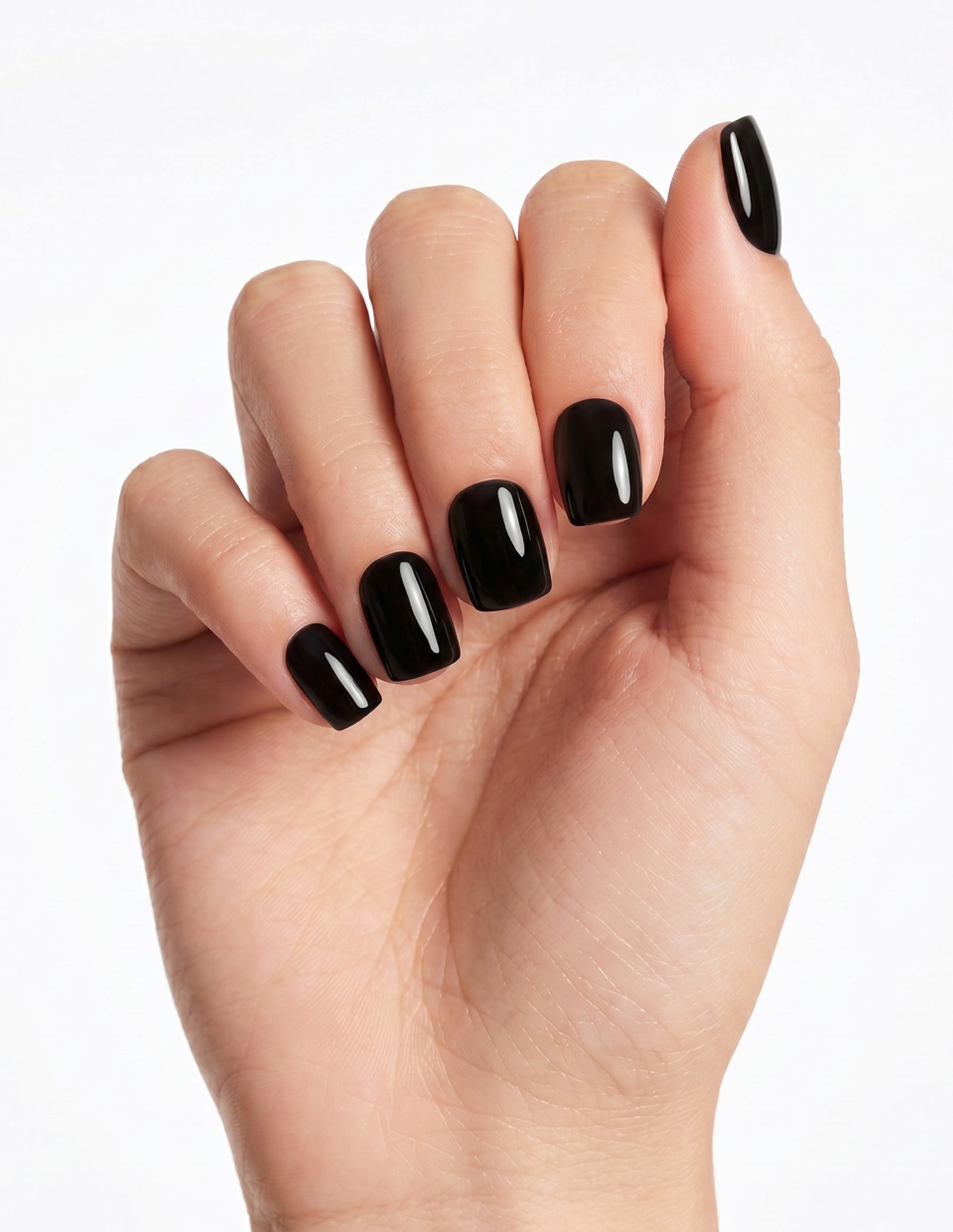 Blackout press-on nails — Coffin (short), light-skin hand, fingers curled