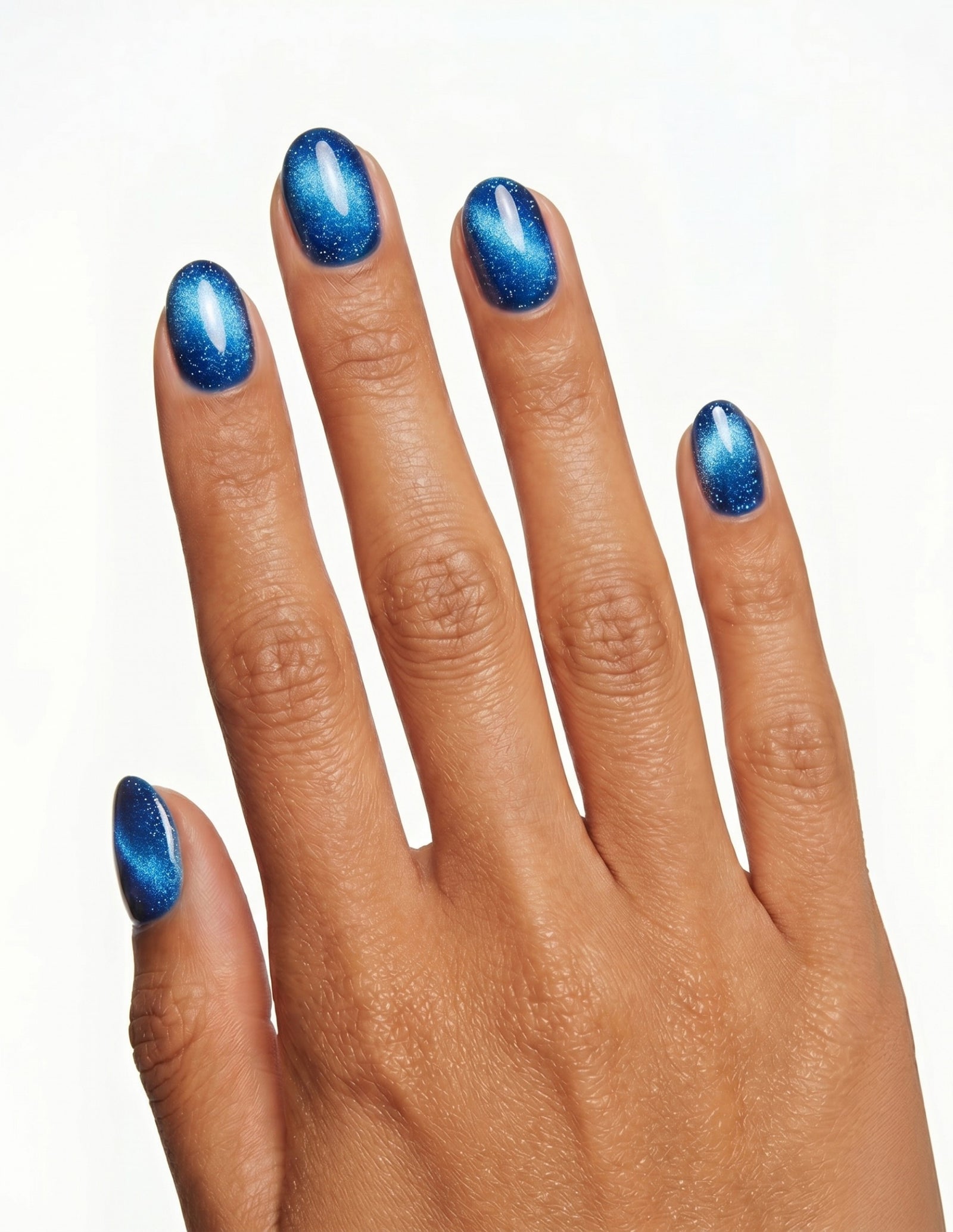 Cobalt press-on nails — Oval (extra-short), tan hand, back of hand