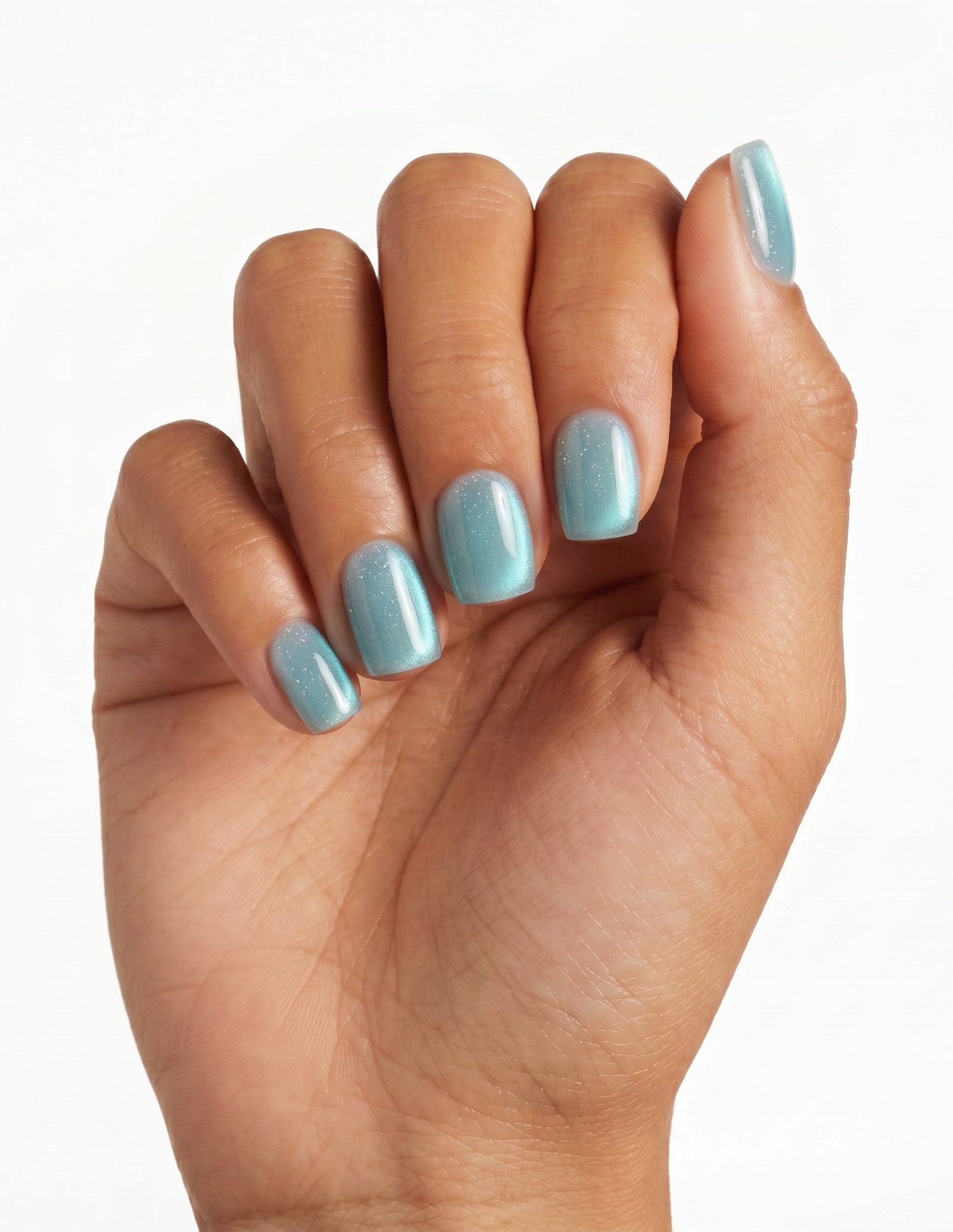 Aurora Lagoon press-on nails — Coffin (short), tan hand, fingers curled
