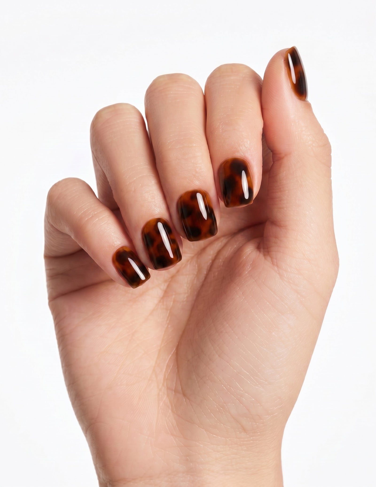 Tortoise press-on nails — Coffin (short), light-skin hand, fingers curled