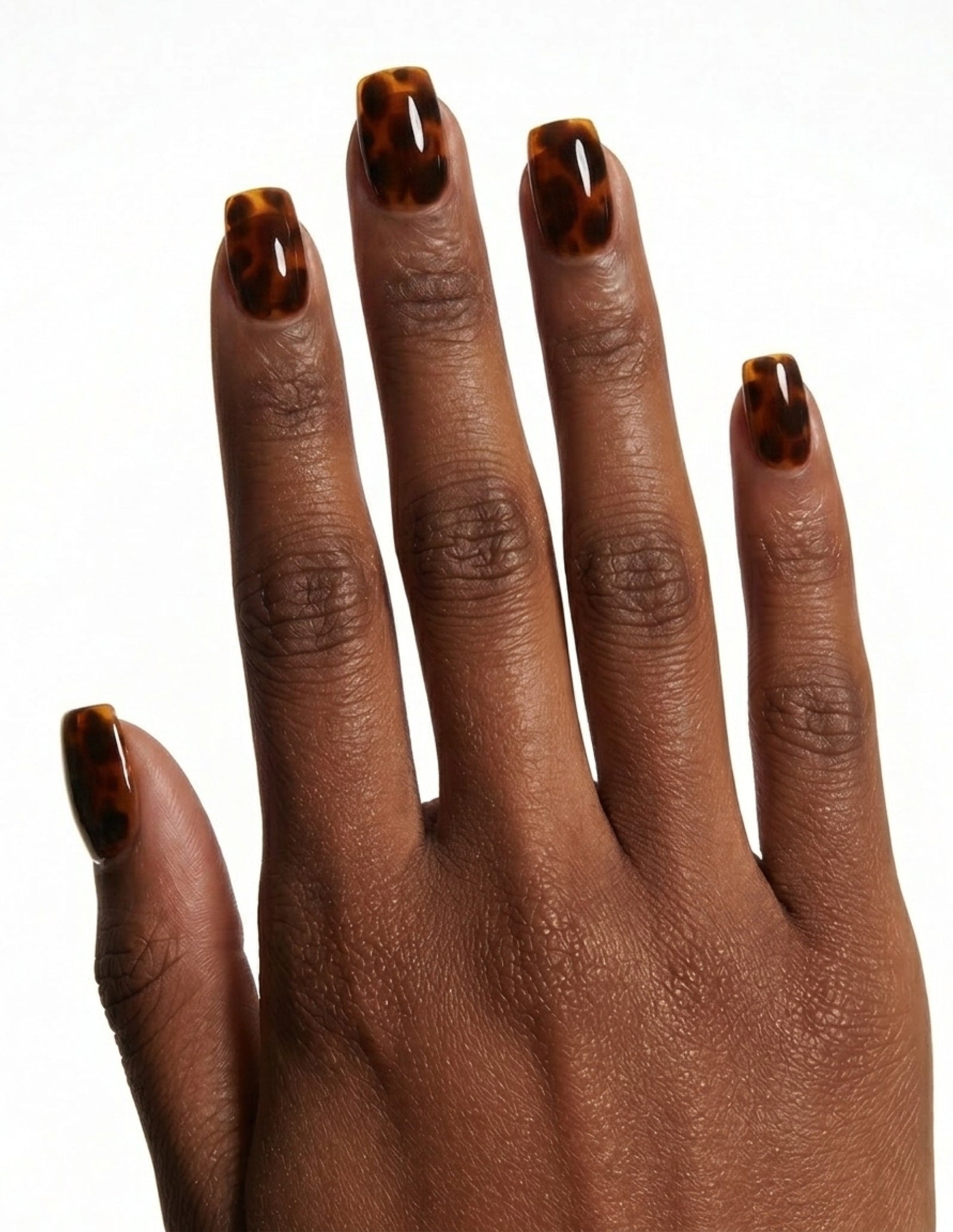 Tortoise press-on nails — Coffin (short), deep-skin hand, back of hand
