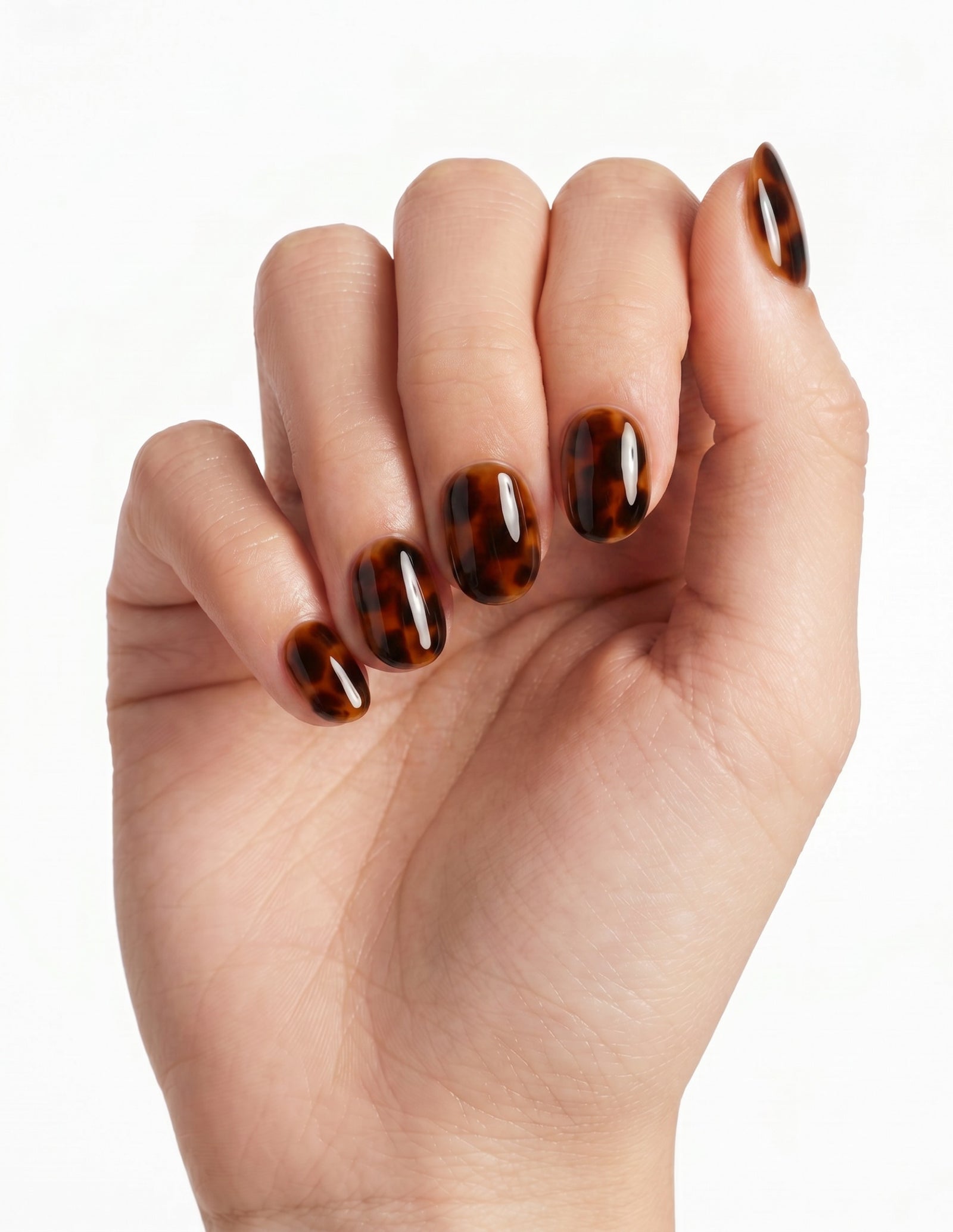 Tortoise press-on nails — Oval (extra-short), light-skin hand, fingers curled