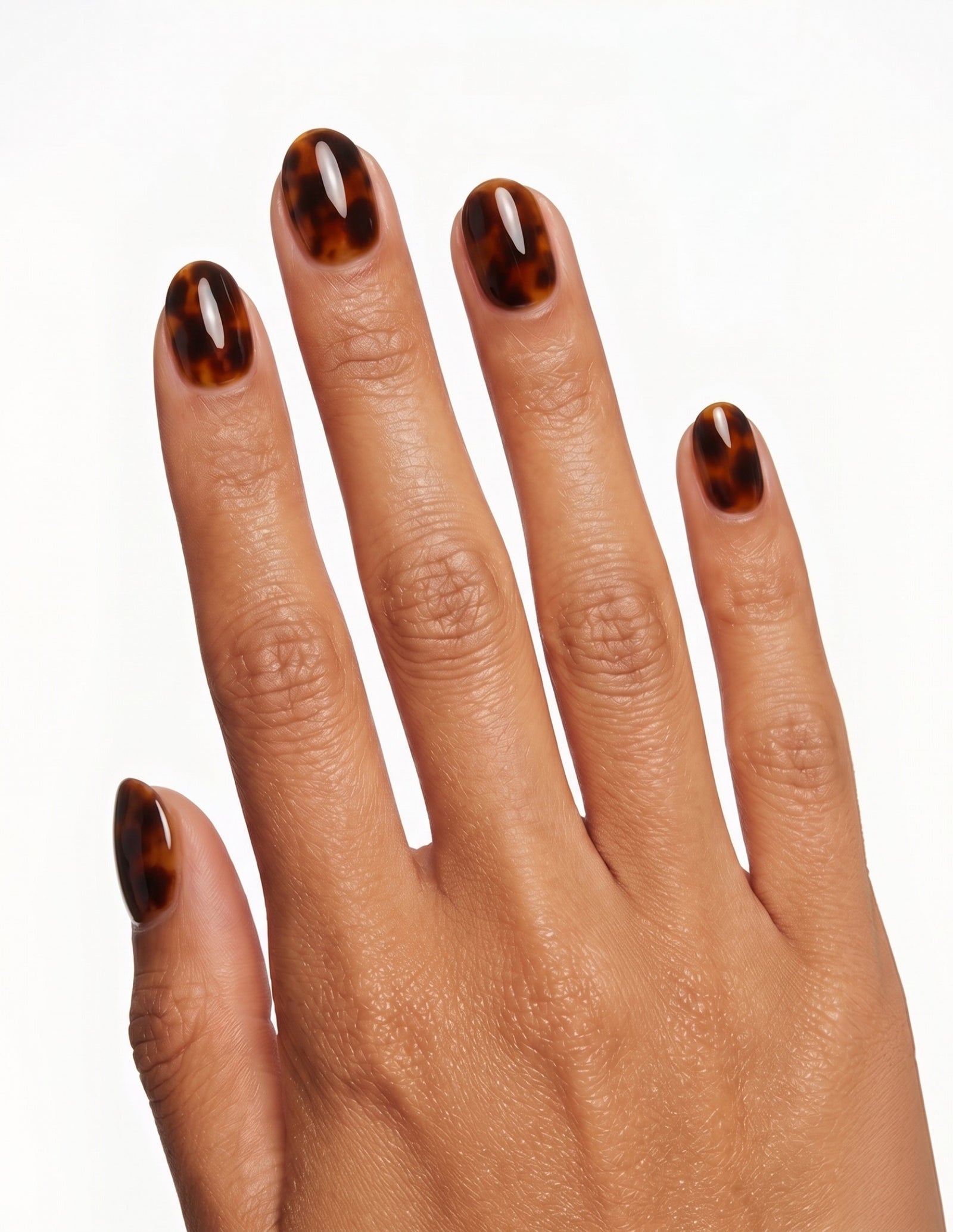 Tortoise press-on nails — Oval (extra-short), tan hand, back of hand