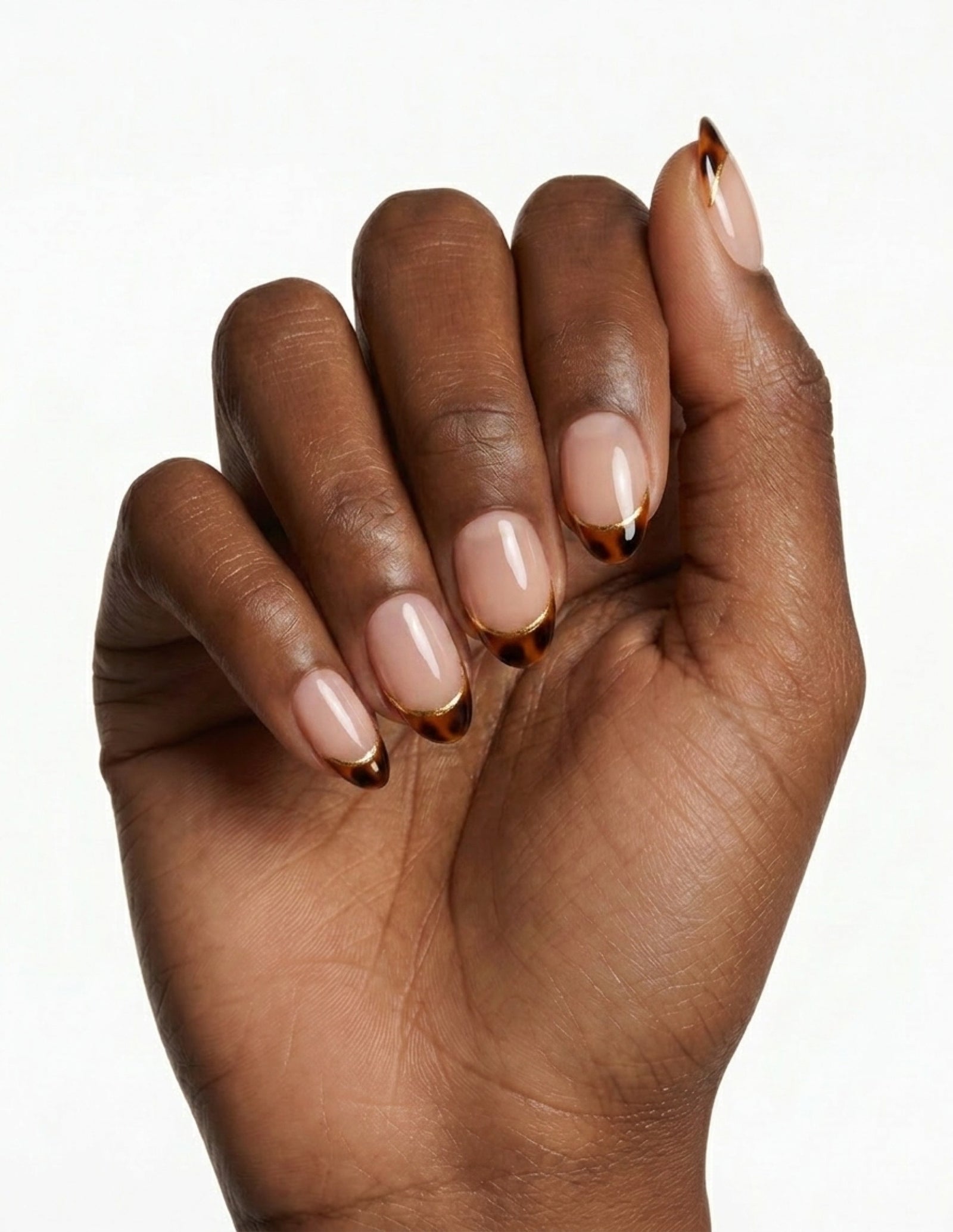 Tortoise Tips press-on nails — Almond (extra-short), deep-skin hand, fingers curled