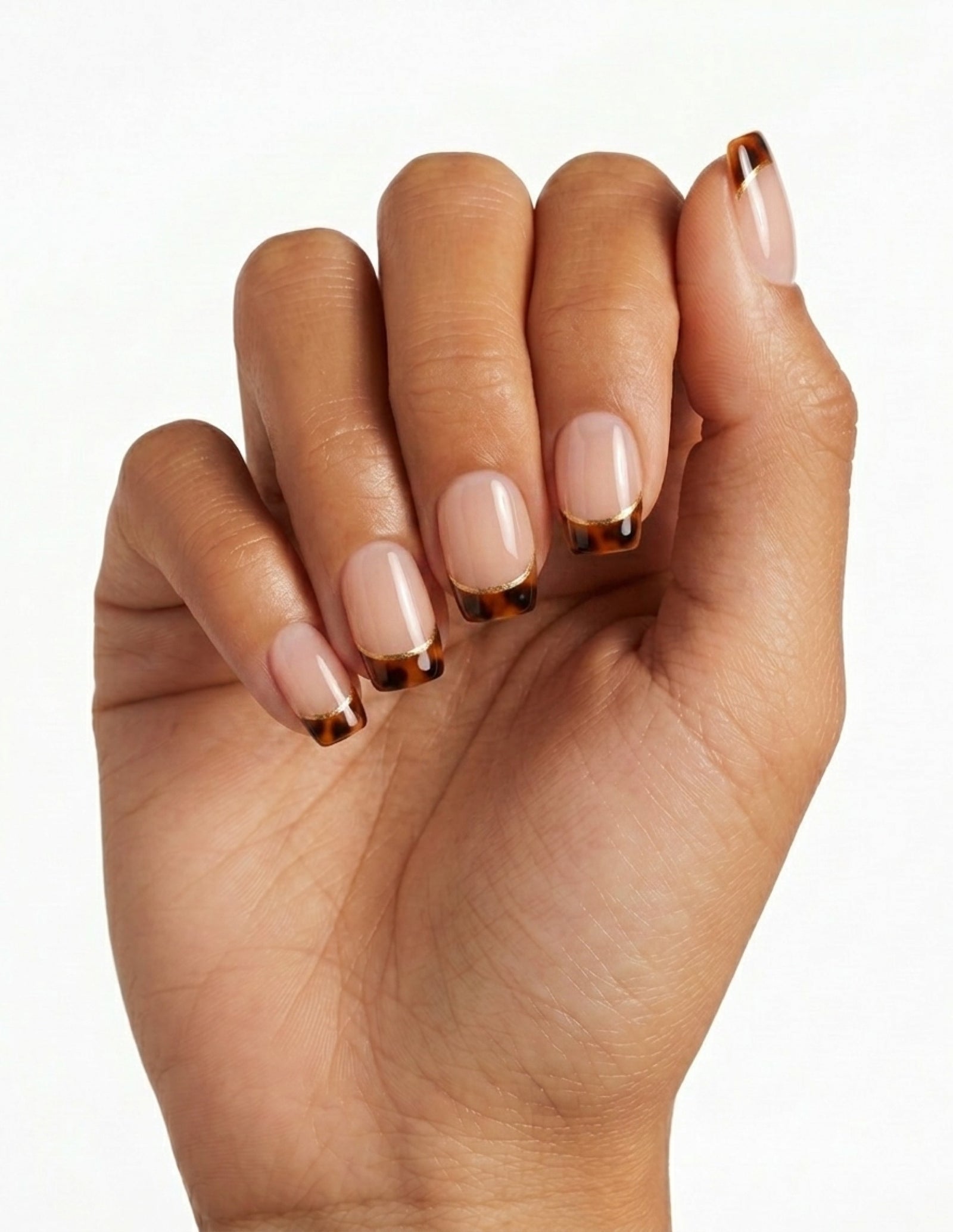 Tortoise Tips press-on nails — Coffin (short), tan hand, fingers curled
