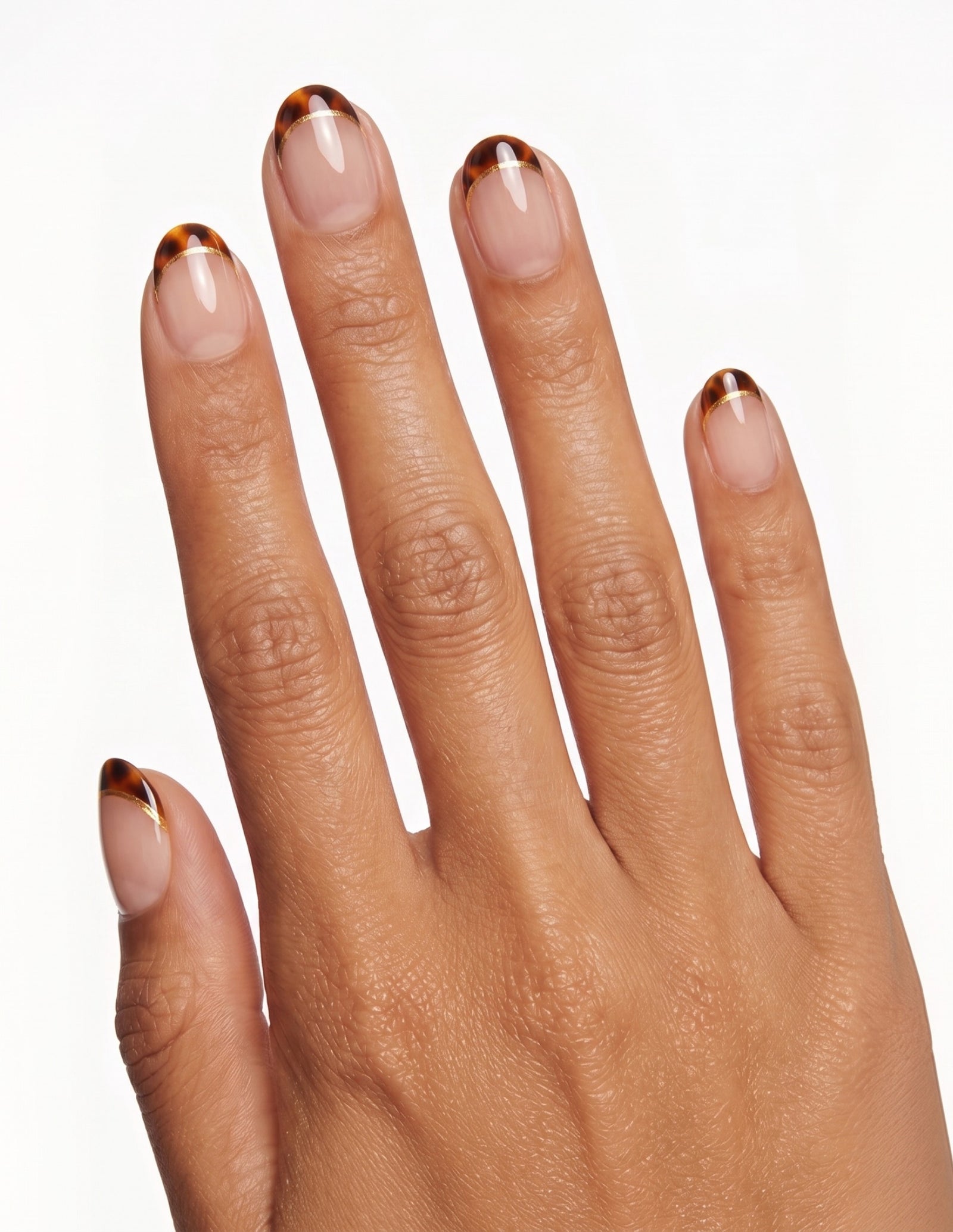 Tortoise Tips press-on nails — Oval (extra-short), tan hand, back of hand
