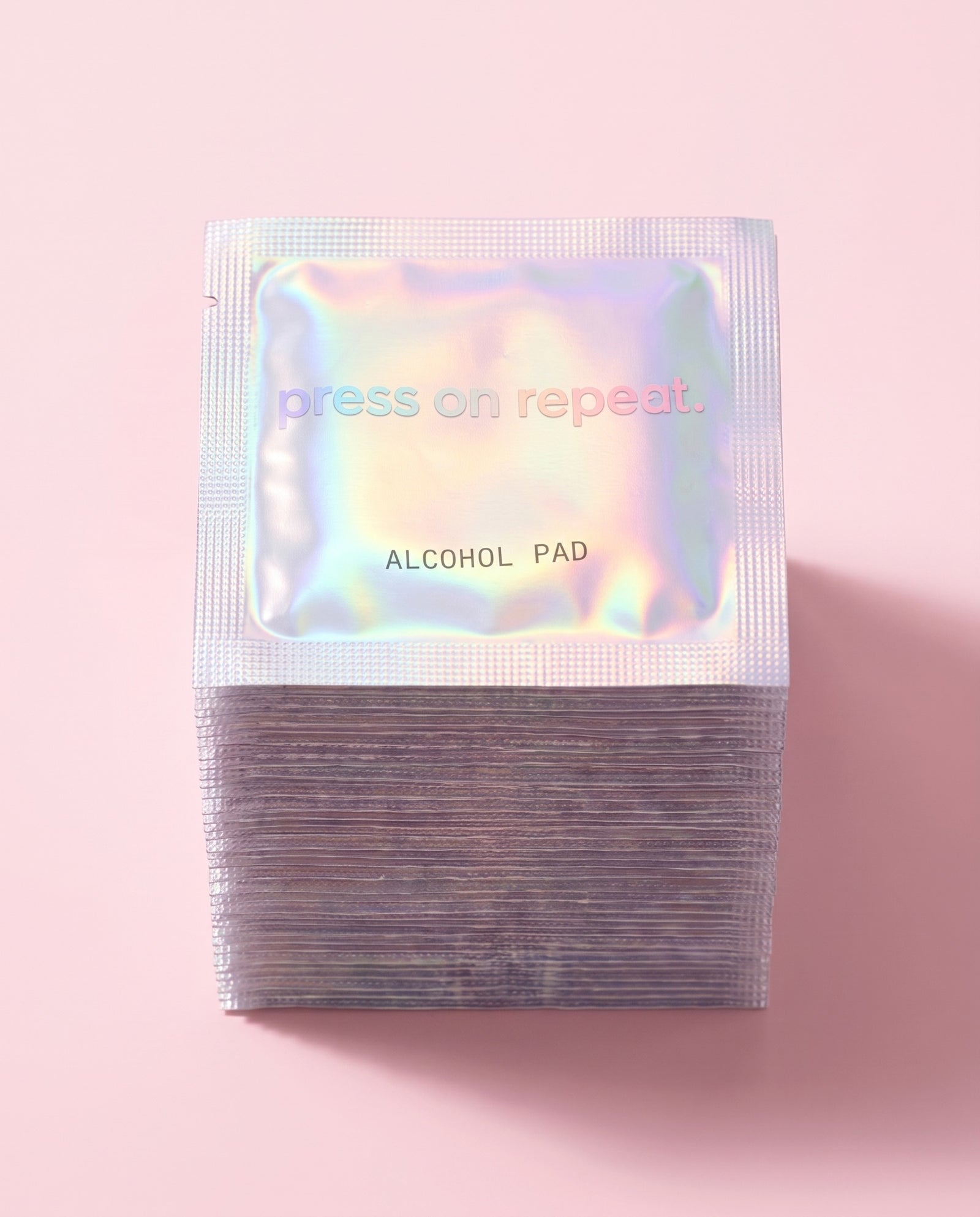 Tall stack of holographic foil alcohol pad sachets for prepping nails before applying press-ons.